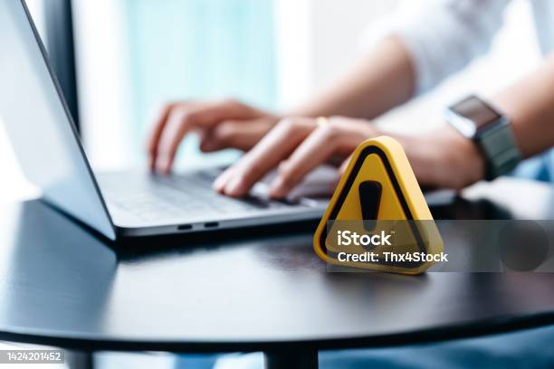 Warning Sign Placed On A Table While Businesswoman Work Stock Photo - Download Image Now