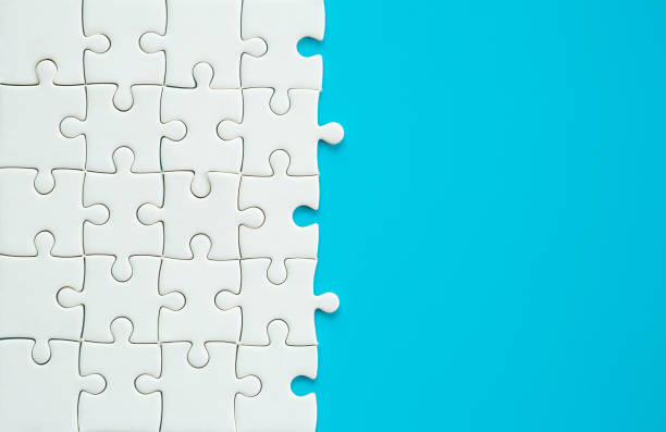 istock White part of jigsaw puzzle pieces on blue background. concepts of problem solving, business success, teamwork, Team playing jigsaw game incomplete, Texture photo with copy space for text 1424203506
