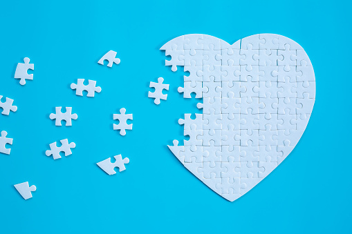 White heart shape of jigsaw puzzle pieces on blue background. concepts of problem solving, business success, teamwork, Team playing jigsaw game incomplete, Texture banner with copy space for text