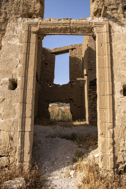 istock Weathered mud brick ruin with sandstone entryway leading to window opening on back wall 1424205158