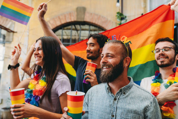 People dancing and having fun together at an LGBTQIA pride event party. LGBTQIA Pride Event concept. Rainbow flags.