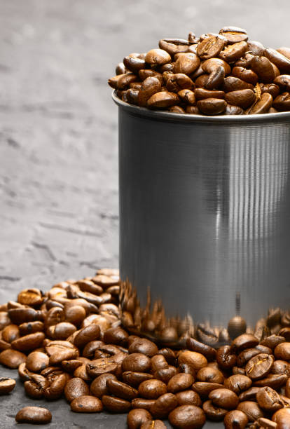 istock Roasted coffee beans in metal cup on a black background.Copy space.Flat lay. Vertical orientation. 1424208090