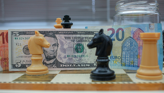euro and dollar fighting face to face on the chessboard of currencies