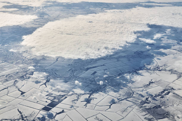 vue aérienne au-dessus des nuages au-dessus des rivières, des champs et des routes enneigés, de l’air frais et glacial de l’hiver - ozone layer photos et images de collection