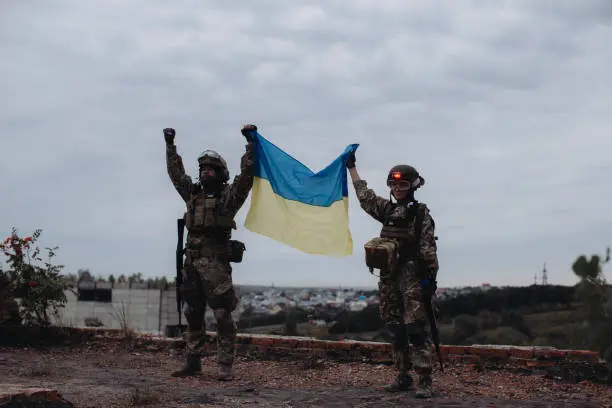 Ukrainian military holds the flag of Ukraine. The concept of victory. The war between Ukraine and Russia.