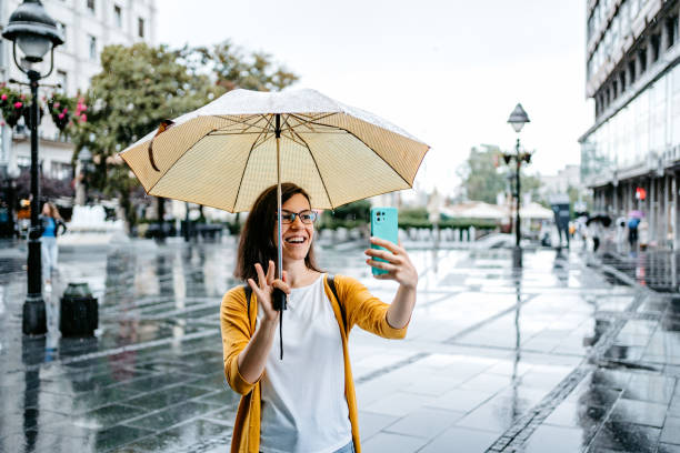 istock Young Woman Having A Video Call Outdoors On A Rainy Day 1424219636
