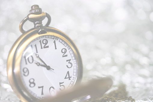 Vintage pocket watch  with blur silver and white bokeh for background and concept idea