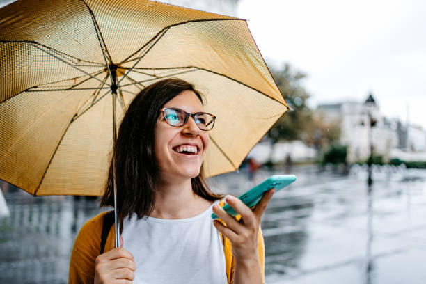 istock Young Woman Talking On The Phone Outdoors On A Rainy Day 1424220027
