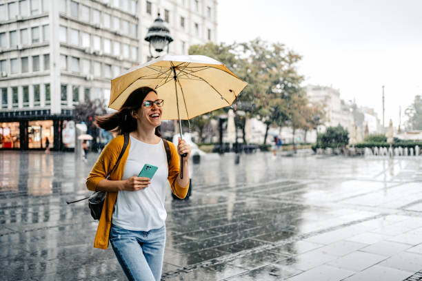 joven huyendo de la lluvia - freedom on the phone urgency telephone fotografías e imágenes de stock