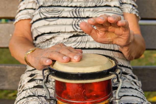 old woman playing an african drum. sociocultural animation - medical animation imagens e fotografias de stock