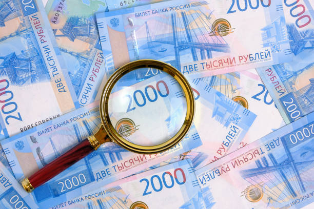istock Magnifying magnifier against background Russian rubles with face value two thousand. 1424221753