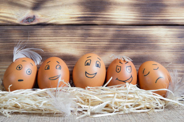 istock Five brown eggs with funny faces on a wooden background 1424224870