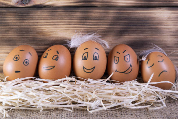 istock Five brown eggs with funny faces on a wooden background 1424224885