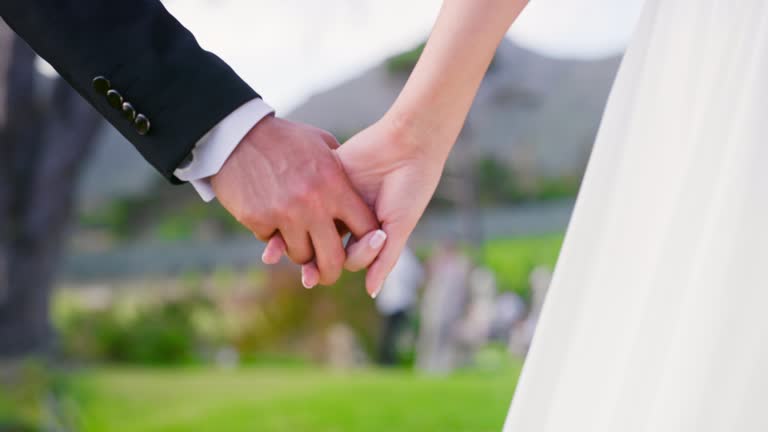 Trust, couple and hands holding in wedding reception ceremony event together with man and woman in love. Support, solidarity and commitment with bride and groom walking to marriage celebration
