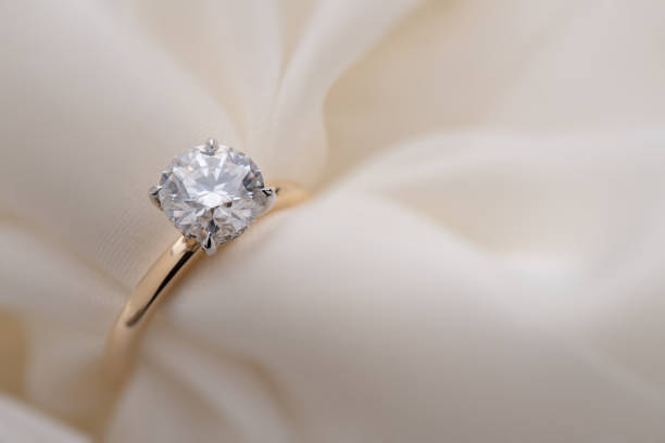 istock Engagement Diamond Ring on Soft White Fabric Background 1424227035