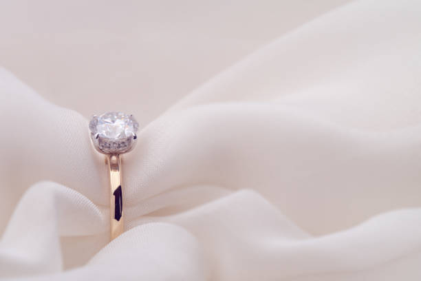 istock Engagement Diamond Ring on Soft White Fabric Background 1424227065