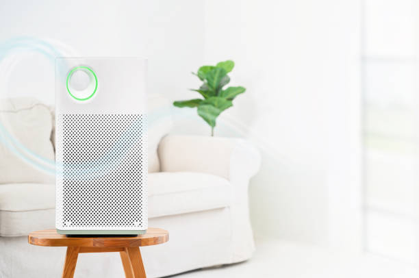 air purifier a living room, air cleaner removing fine dust in house. protect PM 2.5 dust and air pollution concept stock photo