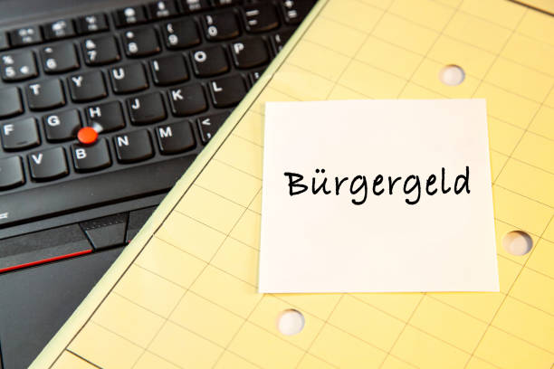 istock Laptop keyboard and yellow Folder map with sticky note message, paper note Buergergeld/Bürgergeld 1424238800