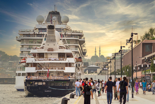 Istanbul, Turkey - August 26, 2022: Galataport , a mixed use development located along shore of Bosphorus strait, in Karakoy neighbourhood, with two large cruises docked, and people waking