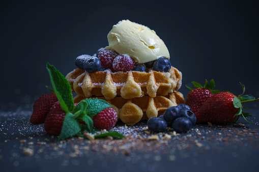 Traditional belgian waffles with fresh blueberries, sugar and raspberries.