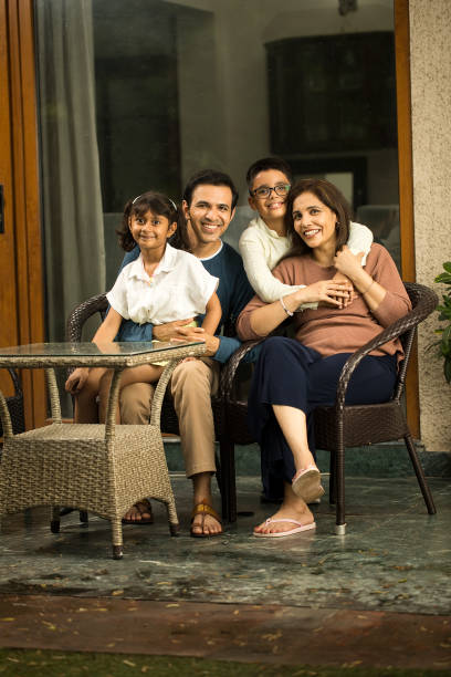 Happy family spending leisure time at terrace Parents with children spending leisure time together at terrace happy indian young family couple stock pictures, royalty-free photos & images