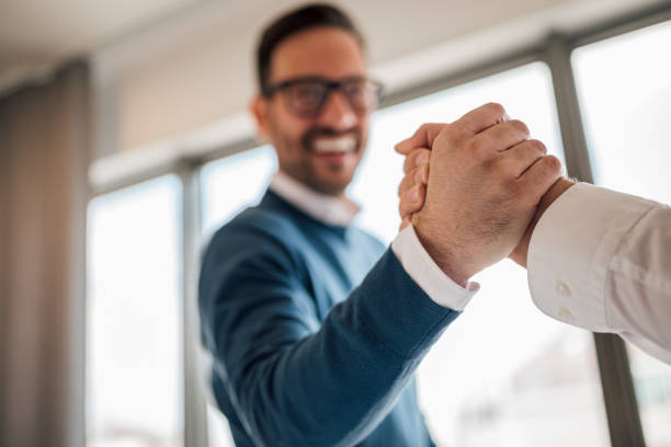 foto de close-up de dois colegas, reconhecendo um ao outro após um projeto de sucesso. - business handshake meeting human hand - fotografias e filmes do acervo