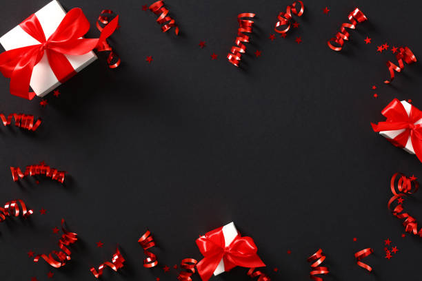 istock Red party streamers, gift boxes and confetti on black background. Banner mockup for Black Friday, Birthday, Valentines Da, Anniversary. 1424247165