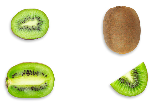 Green and yellow kiwi fruits on a plate top view