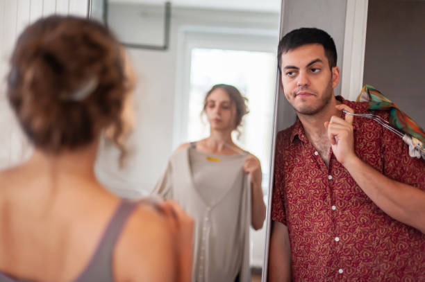 istock Exhausted man looks at woman as he changes clothes 1424251801