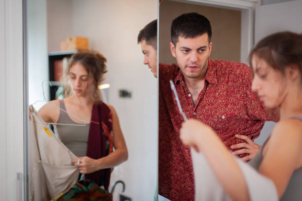 istock Exhausted man looks at woman as he changes clothes 1424252551