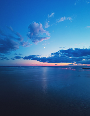Aerial view of crescent Moon reflecting over the Northumberland Strait in Prince Edward Island.