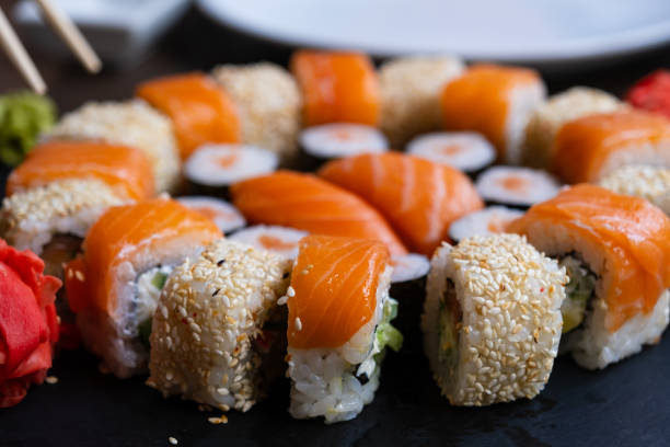 istock Sushi set close-up on black board. Traditional Japanese seafood 1424256547