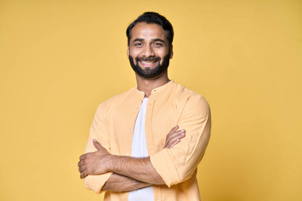 istock Smiling confident bearded indian man standing isolated on yellow background. 1424261847