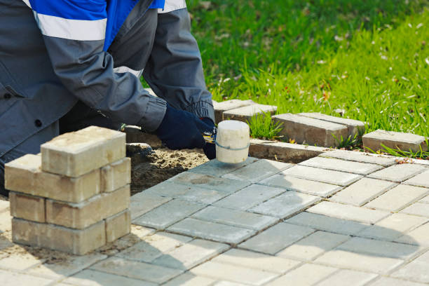 istock Bricklayer lays paving slabs outside. Working man performs landscaping. Builder lays out sidewalk with stone blocks. 1424261874