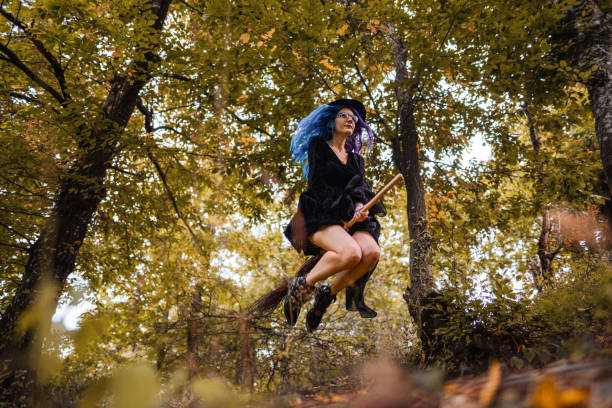 istock Young witch flying on a broom through the woods on Halloween 1424262766