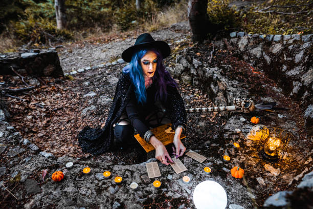istock Young witch reading tarot cards and telling fortune in the woods 1424263498