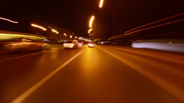 Car driving. Car running. Time lapse. The reflected lights of the city. View from the front hood of the car.