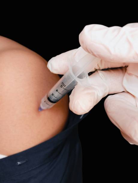 Vaccination booster dose injection shot jab immunization inoculation for covid19 coronavirus pandemic disease with syringe needle prick on human arm shoulder muscle by doctor nurse in hospital clinic closeup view image photo vacunación dosis de refuerzo inyección inyección jab inmunización inoculación para la enfermedad pandémica por coronavirus covid19 con pinchazo de aguja de jeringa en el músculo del hombro del brazo humano por enfermera médica en el primer plano de