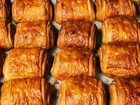 High angle color image depicting freshly baked pain au chocolat in a row and for sale at the bakery.