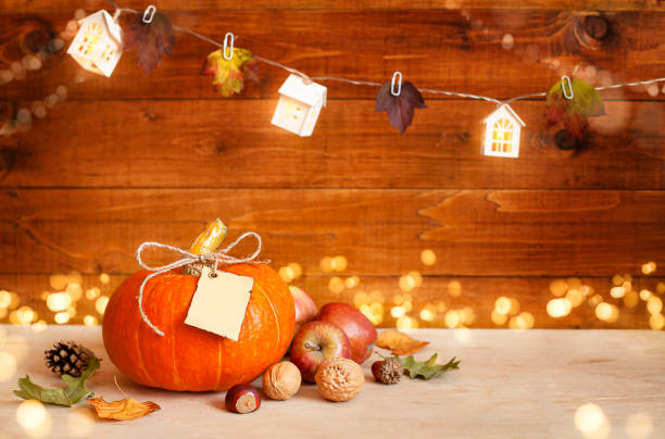 pumpkin with paper tag on wooden table with bokeh - cartão de felicitação imagens e fotografias de stock