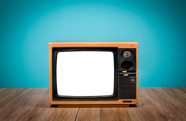 istock Vintage yellow old TV cut out screen on wooden table with mint blue gradient background. 1424274652