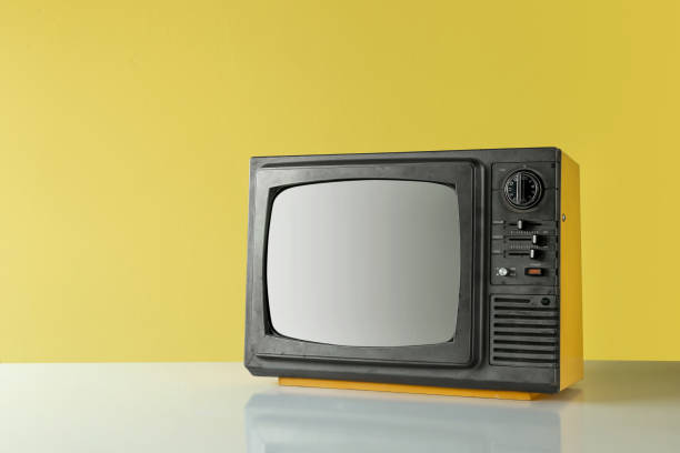 istock Retro yellow old TV on table with yellow wall background 1424274773