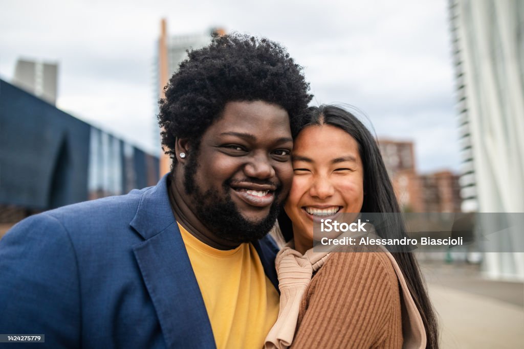 Happy young multiracial friends having fun hanging out in city Couple - Relationship Stock Photo