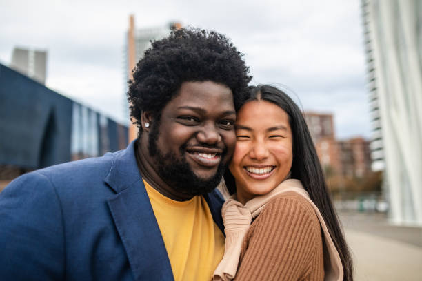 Happy young multiracial friends having fun hanging out in city stock photo