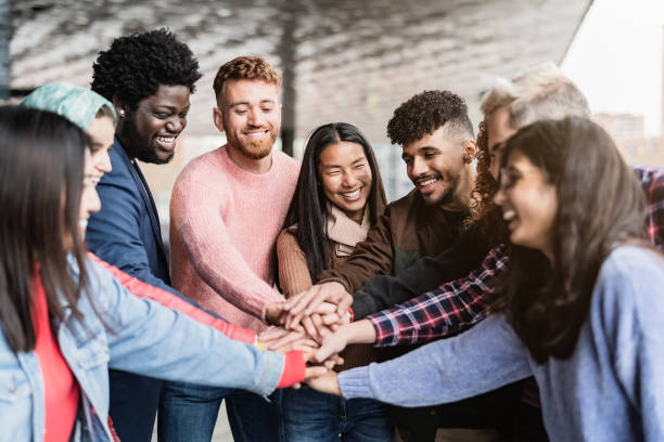 jeunes amis multiraciaux empilant les mains à l’extérieur - concept d’amitié et de diversité - vêtement modeste photos et images de collection