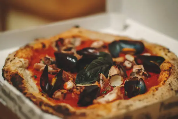 Photo of Pizza with mussels, squid and clams. Frutti di mare.