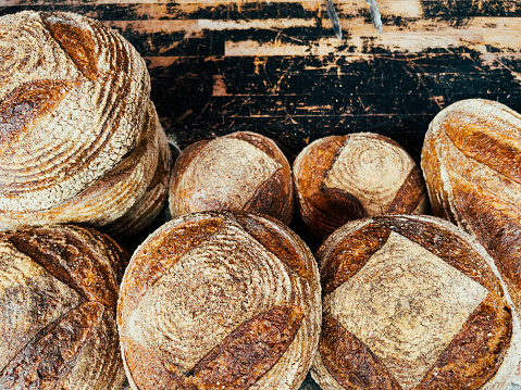 High angle color image depicting freshly baked artisan sourdough bread loaves stacked and for sale at the food market. Room for copy space.