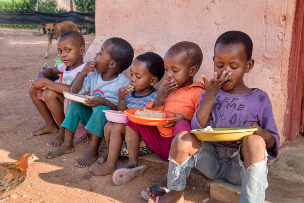 afrikanische kinder essen - underdeveloped stock-fotos und bilder