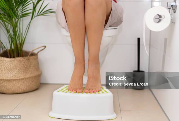 Woman Putting Your Feet On Bathroom Benches During Emptying Stock Photo - Download Image Now