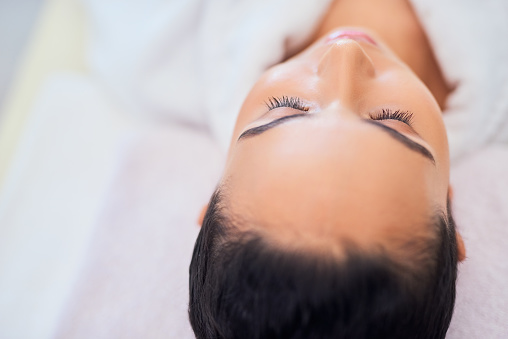 Spa facial, relax and luxury skincare treatment on a young woman with a healthy lifestyle. Closeup of a calm, selfcare and bodycare lady at a wellness, health and beauty cosmetic clinic or salon.